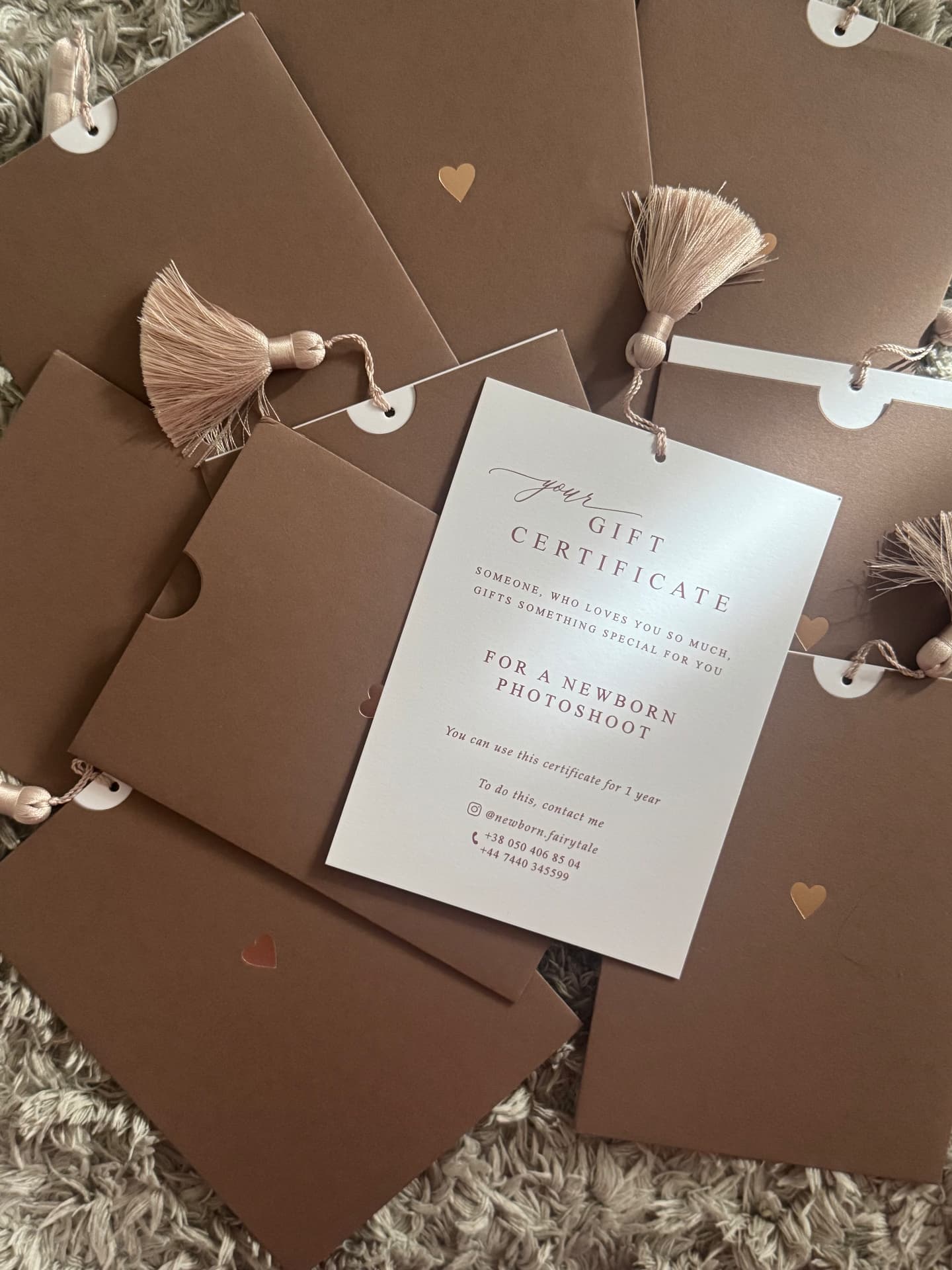 Printed Newborn Fairytale gift certificate for a newborn photoshoot with blush tassel and clay-brown gift sleeves